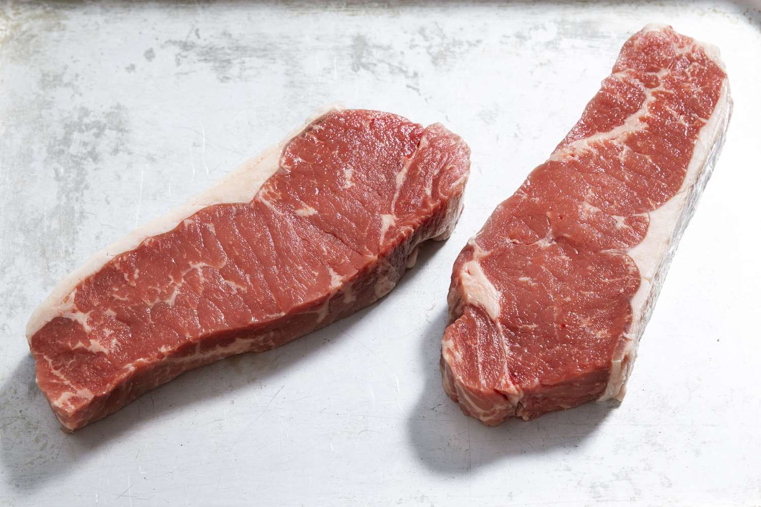 Raw fresh sirloin steaks grain fed on a silver tray